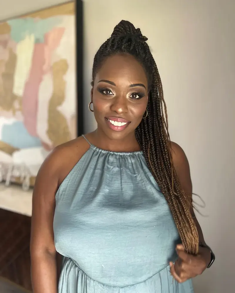 Smiling client with long braids and soft glam makeup